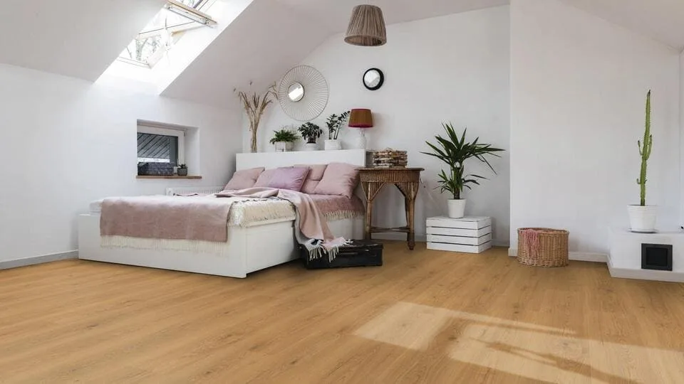 Camera mansardata con pavimento in legno chiaro a listoni